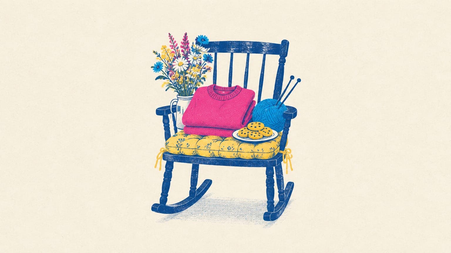A folded crewneck sweatshirt on a rocking chair cushion with wildflowers, knitting yarn and cookies