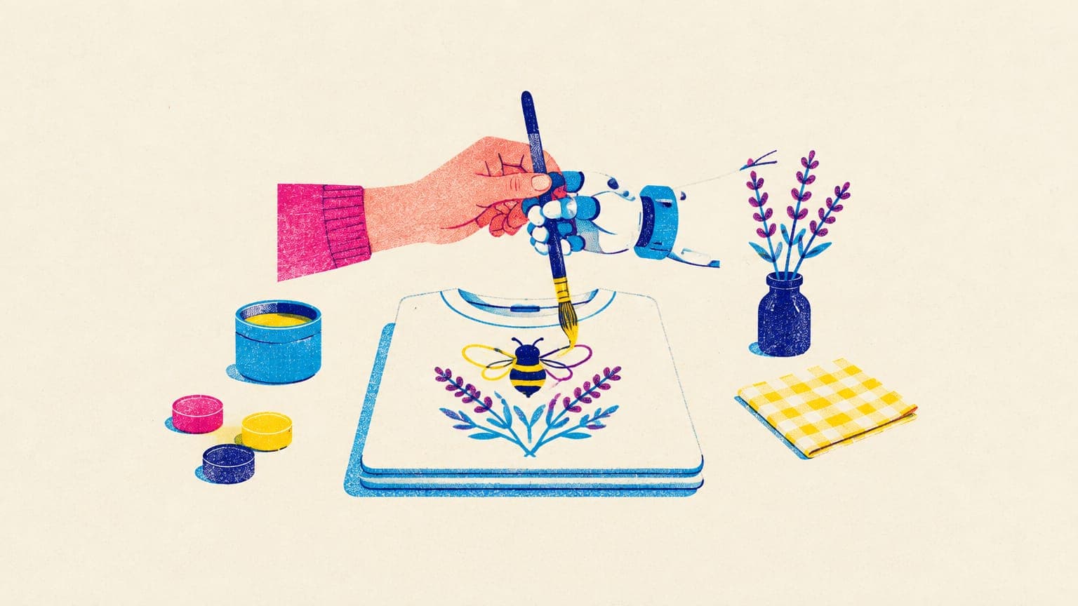 A human hand and a robot hand holding one paintbrush over a t-shirt printed with a honeybee and lavender motif
